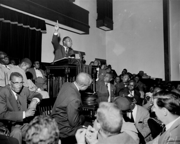 The Rev. Martin Luther King, Jr. is shown speaking to an overflow crowd at a mass meeting at the Holt Street Baptist Church